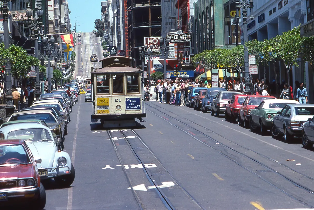 View of a bustling San Francisco street with a cable car and classic architecture.