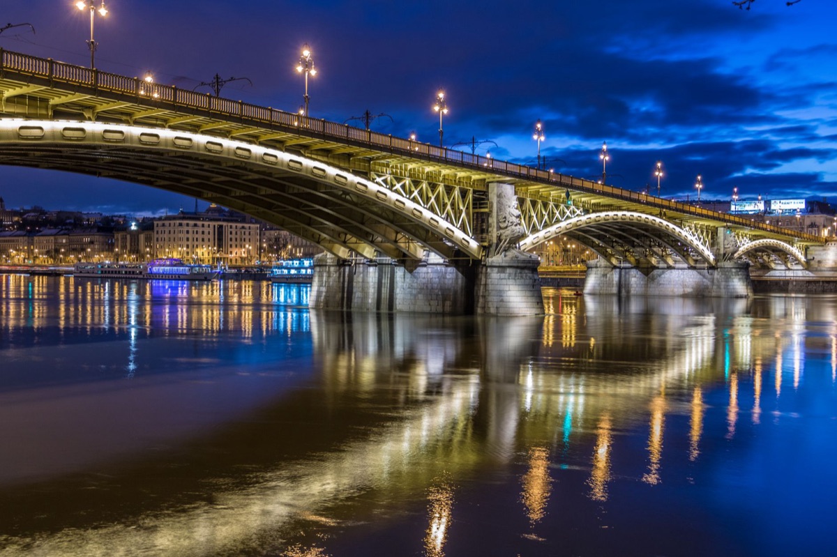 Ponte do Gyeongbok no entorno da cidade, com luzes de neônio e veículos no centro da cena.