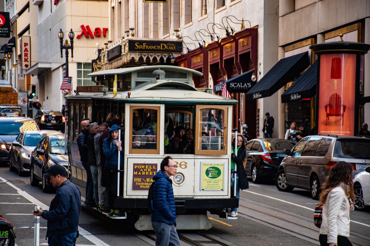 Arrêt d'un câble à San Francisco, avec des passagers en train de descendre de la voiture.