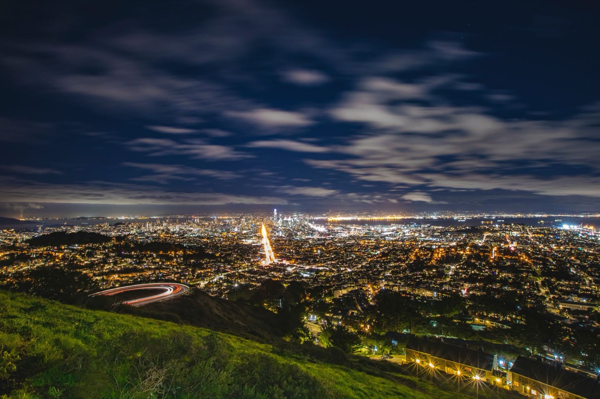 Vue de la ville de San Francisco à l'heure du coucher du soleil, avec des lumières dorées projetées sur les bâtiments.