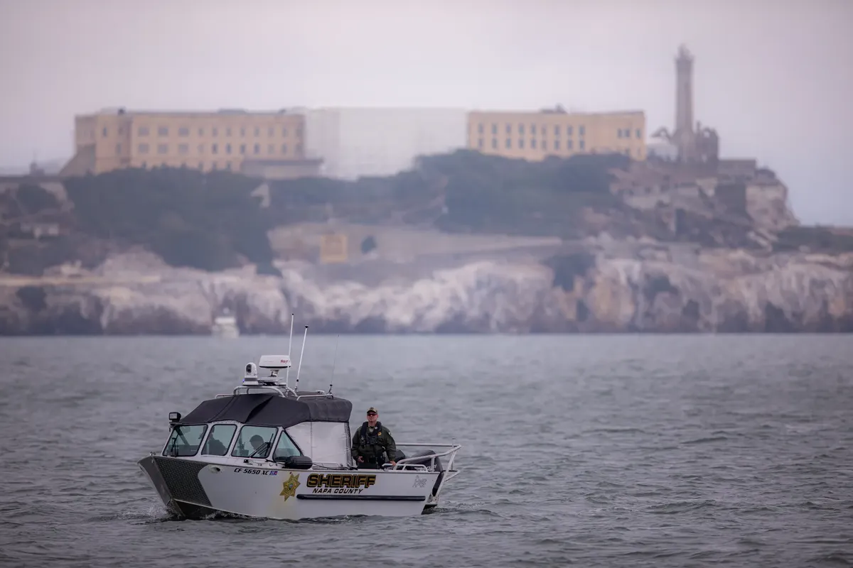 Sheriff boat patrols San Francisco Bay with Alcatraz Island in the background.